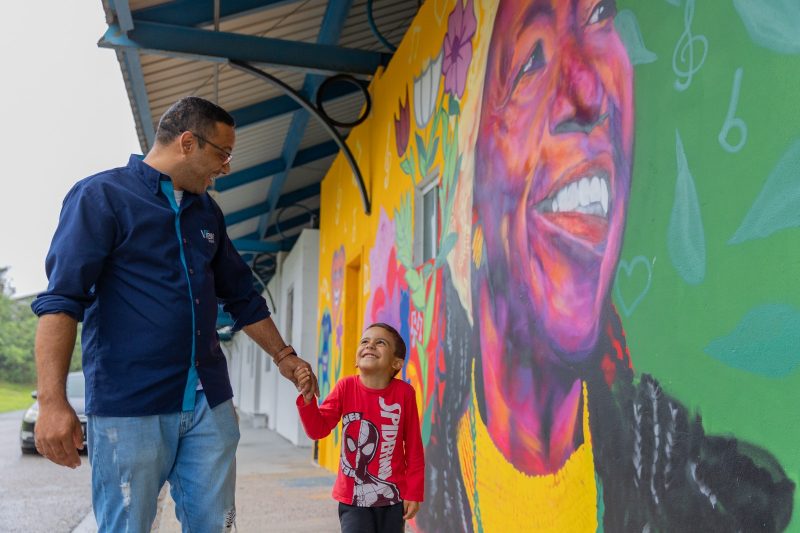 Fabiano Motta, voluntário na Escola Olodum Sul, com o filho Vicente - Foto: Germano Rorato/ND