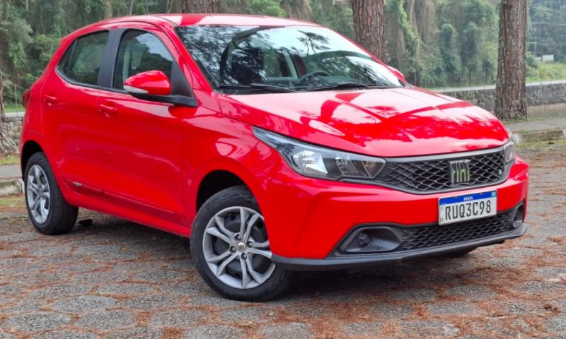 Fiat Argo na cor vermelha estacionado com árvores ao fundo