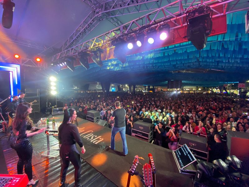 Palco com banda e público assistindo