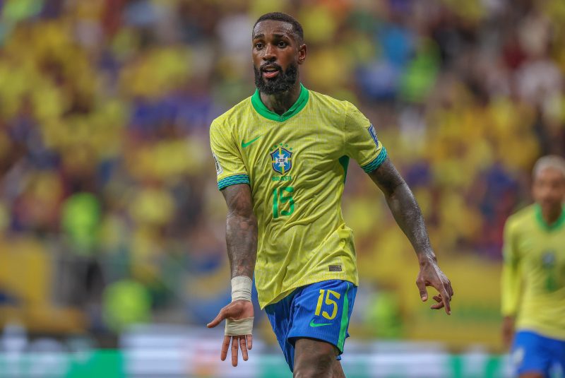 Gerson estica o braço durante jogo da seleção brasileira