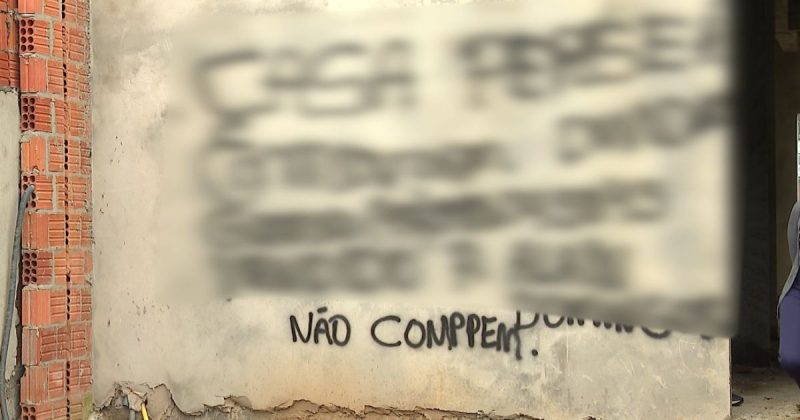 Famílias escrevem em parede de sobrado para alertar golpe imobiliário em Penha