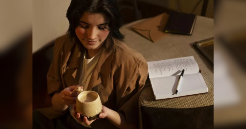 Mulher segurando xícara perto de mesa Mulher segurando xícara perto de mesa
