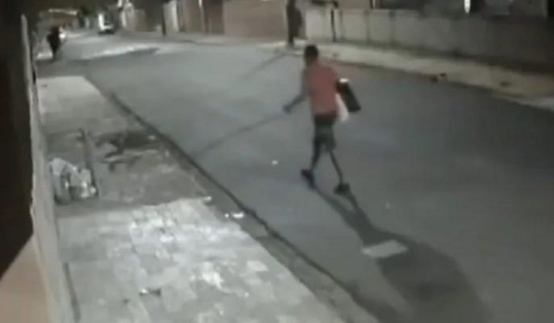 Homem andando na rua carregando televisão após espalhar cocô em unidade de saúde em São Paulo