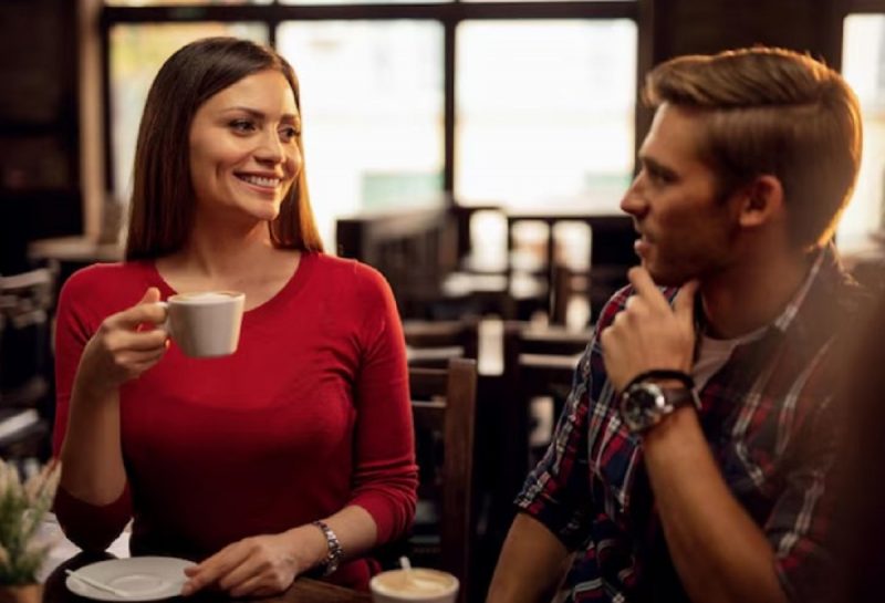 na imagem o homem e a mulher aparecem usando a linguagem corporal enquanto flertam