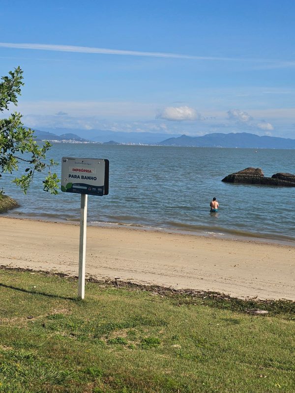 Homem tomando banho na Beira-Mar Norte, imprópria para banho