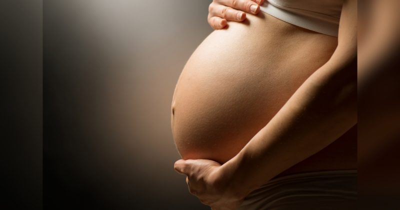 Mulher grávida segurando sua barriga