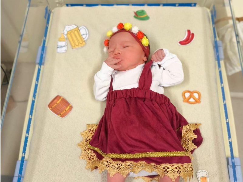 A imagem mostra uma bebê vestida de frida para homenagear a Oktoberfest.