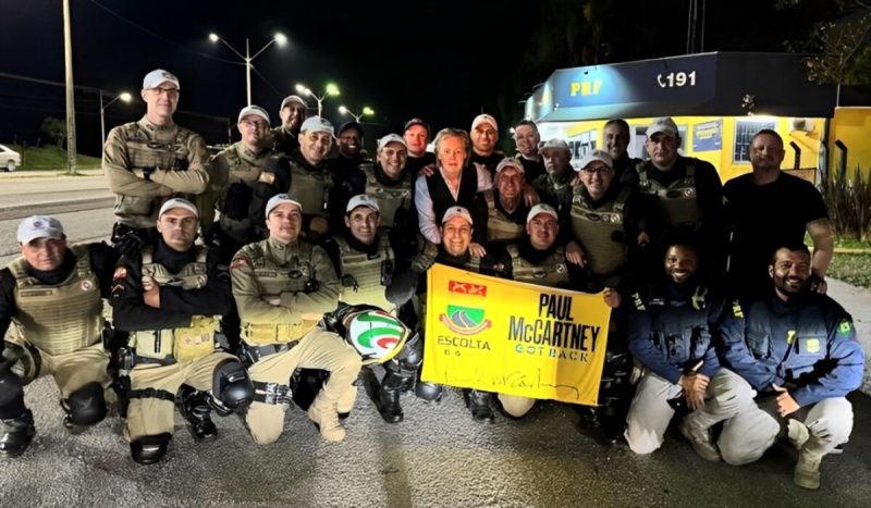 Paul McCartney tirando foto com policiais fardados no meio da rua em Florianópolis