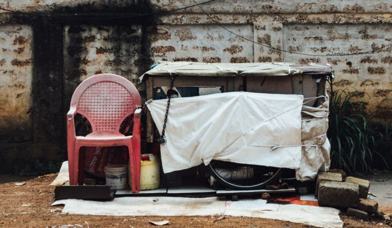 foto de cadeira plástica e casa improvisada na rua, remetendo à miséria e ao Mapa da Fome