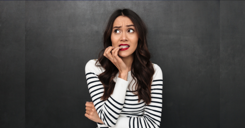 Mulher em dúvida com batom vermelho e dedos na boca