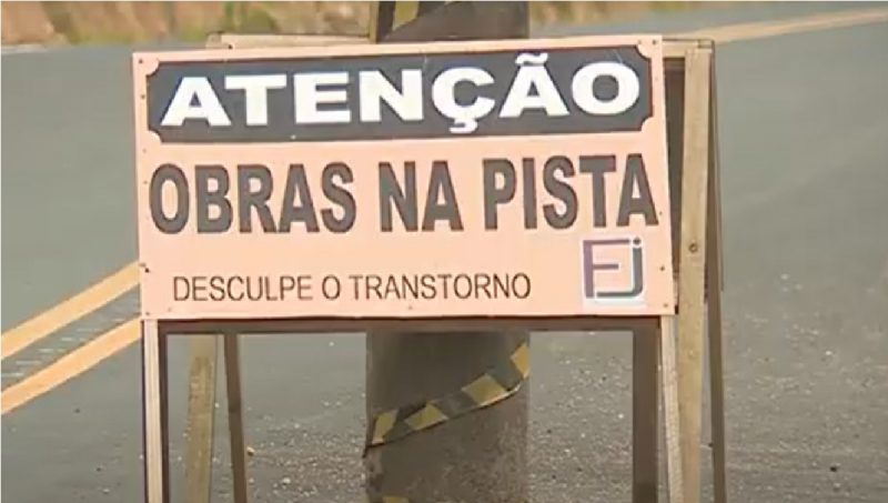 Placa de atenção colocada em poste no meio da rua 