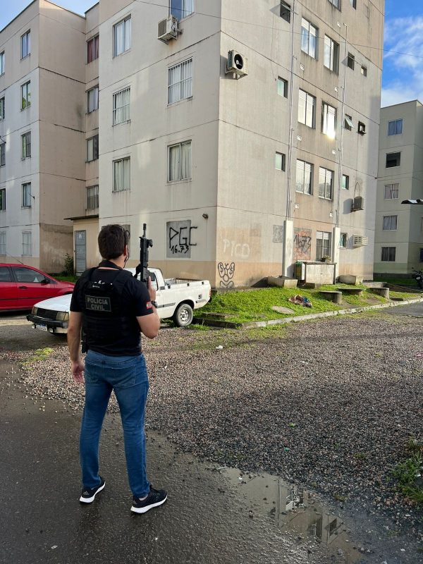 Policial civil em frente à residencial onde suspeitos estariam vivendo em Blumenau