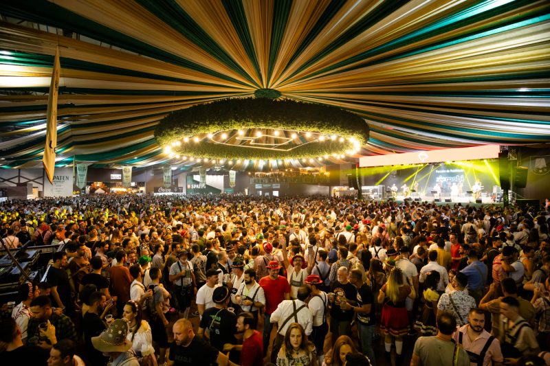 A imagem mostra o pavilhão do Parque Vila Germânica cheio durante a Oktoberfest Blumenau 2024