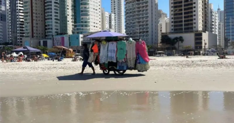 Ambulante e banhistas em praia de Balneário Camboriú