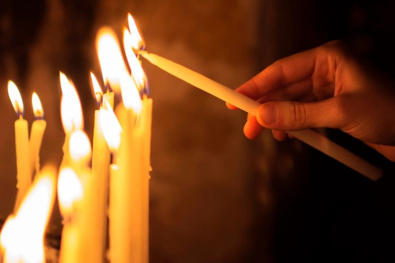 Pessoa acendendo velas em ritual religioso