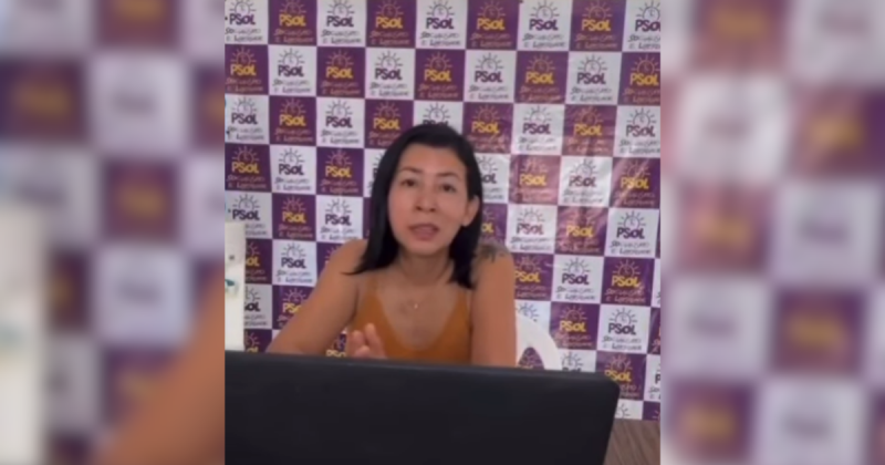 Candidata a vice-prefeita falando em vídeo por trás do painel do PSOL