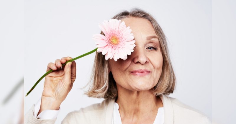 Senhora com flor na mão, mas na região dos olhos