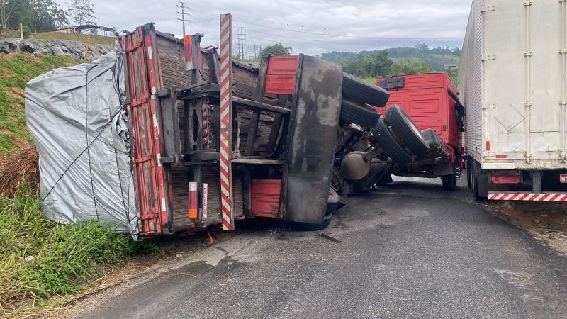 A imagem mostra a carreta tombada na BR-470.