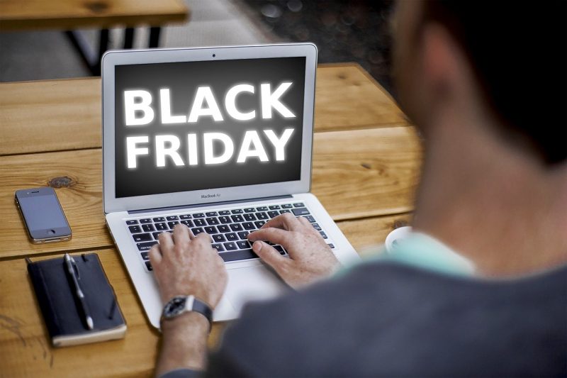 Imagem de um homem com computador na mesa, cuja tela que está escrita Black Friday 