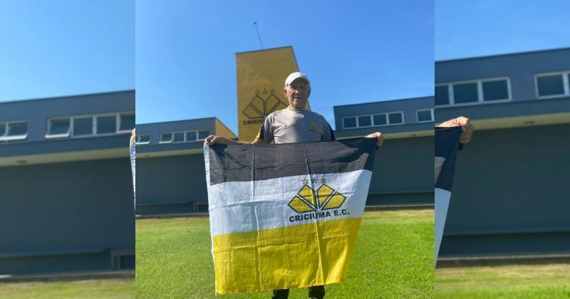 Seu Pedrinho com a bandeira do Criciúma em frente ao CT Antenor Angeloni