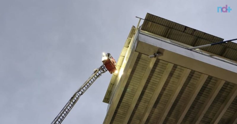 Imagem mostra ação dos bombeiros para ajustar parte do telhado da passarela de Balneário Camboriú que foi levado pela ventania