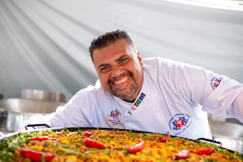 Foto mostra chef com prato de comida na Torresmofest