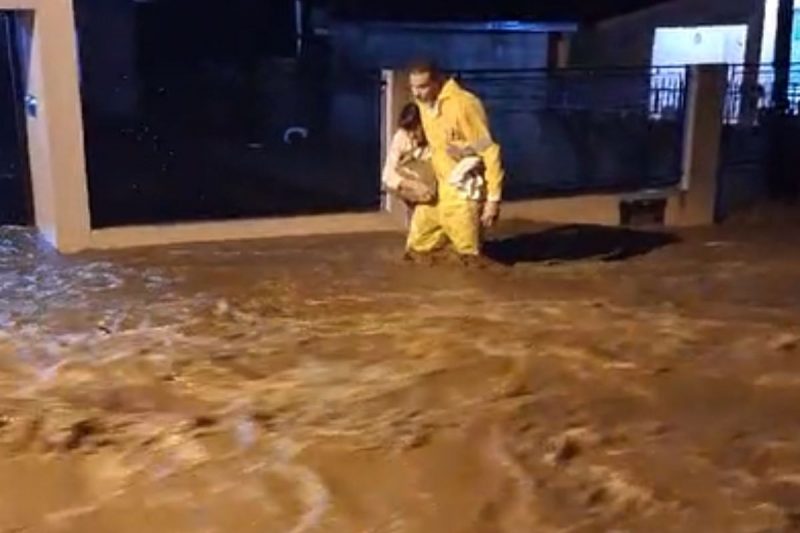 idosa sendo retirada de casa em meio a inundações