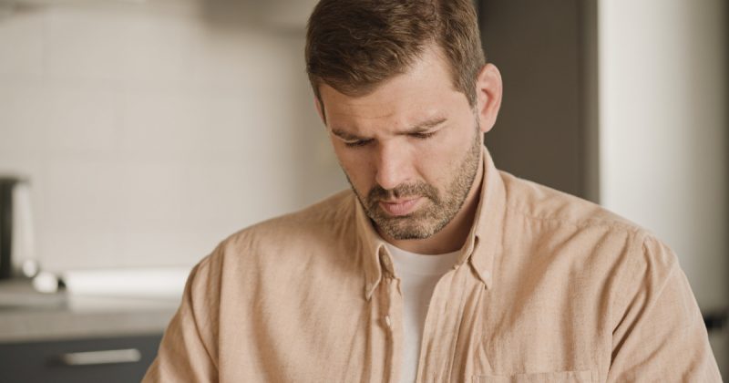 Homem triste com cabeça virada para baixo