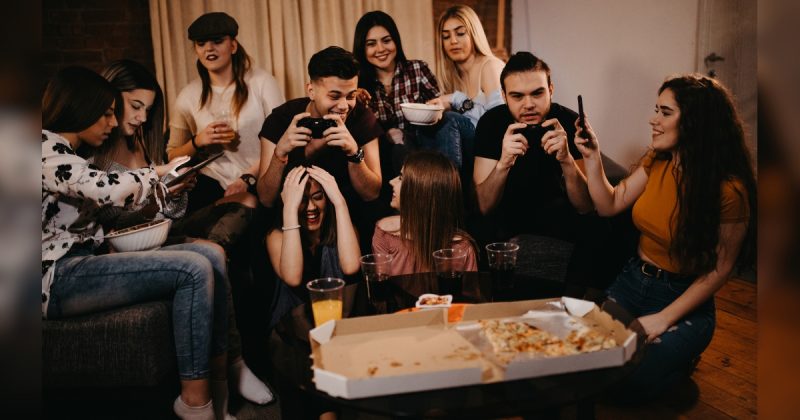 Amigos brincando enquanto outros jogam futebol