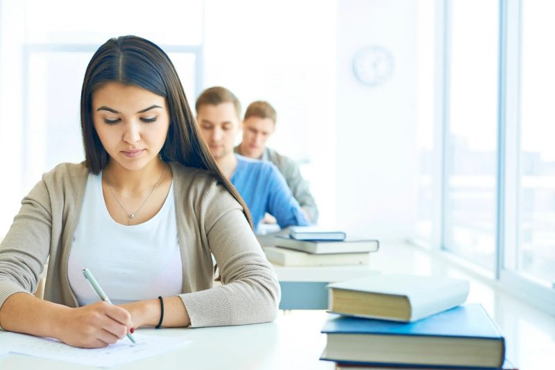 Estudantes fazendo prova em sala de aula