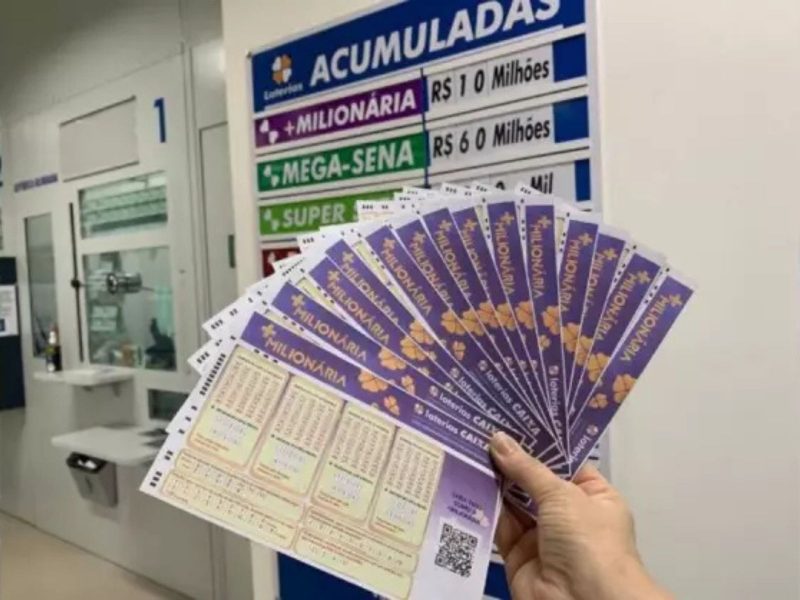 Pessoa segurando bilhetes da +Milionária 235 em loteria