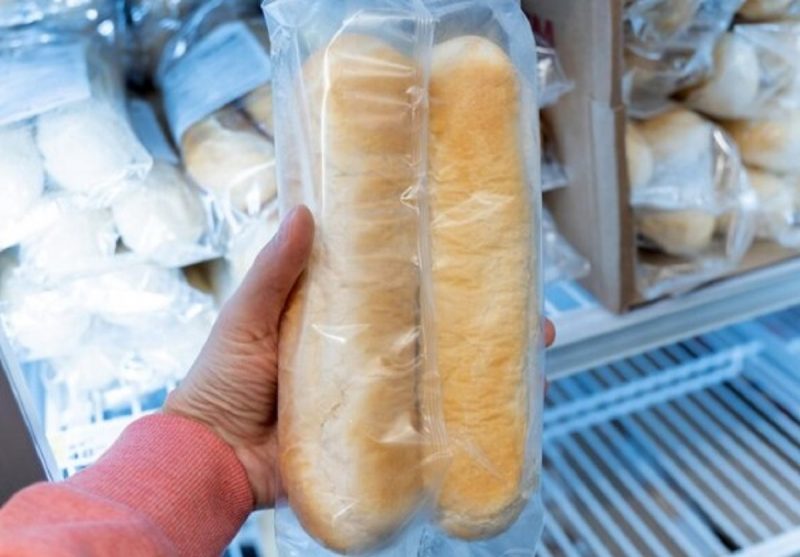 na foto aparece uma pessoa pensando em guardar o pão embalado na geladeira ou no freezer