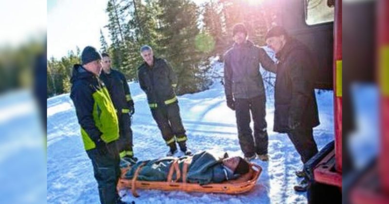 Pessoas em volta de homem que sobreviveu preso sob a neve