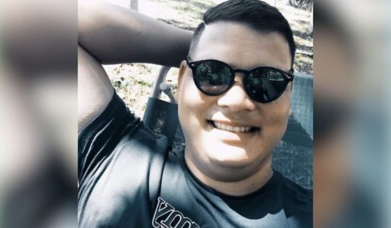 morte de vigilante atingido por quatro tiros, foto mostra homem sorrindo, de óculos escuros e uma mão atrás da cabeça