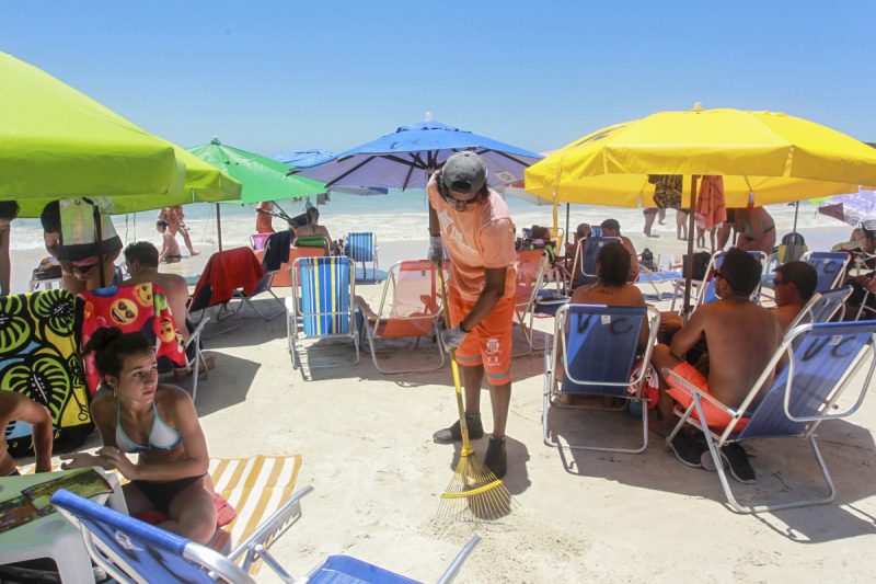 Na foto, homem limpa praia, que ilustra destino de recursos da TPA de Bombinhas. 