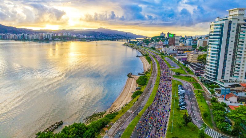 Foto mostra meia maratona vista de cima, unindo-se à paisagem de Florianópolis