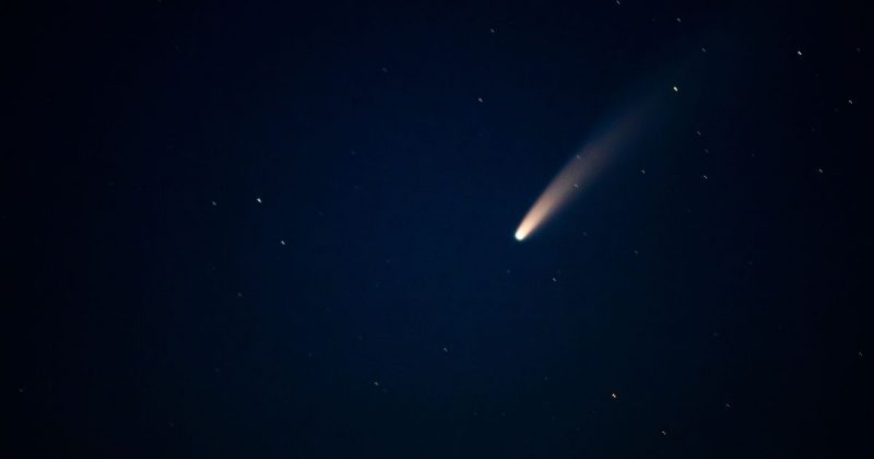 Imagem de cometa passando por céu escuro