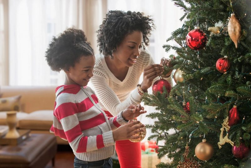 Mulher a montar a árvore de Natal com sua filha