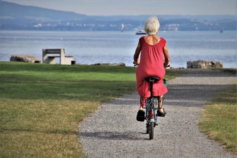 Mulher idosa andando de bicicleta em um mundo que houve a extinção dos homens