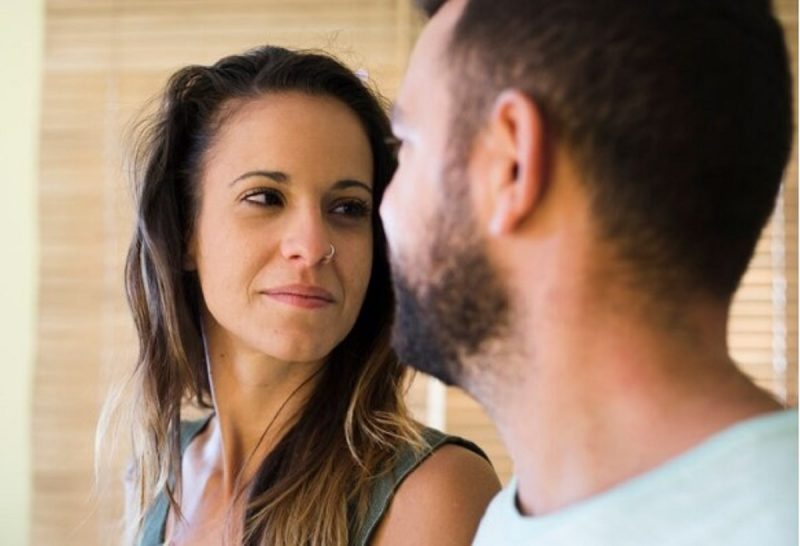 na foto aparece uma mulher olhando para homem representando sinais que não consegue te esquecer