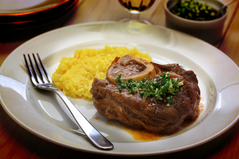 Imagem de um ossobuco, pedaço de carne acompanhado de um risoto 