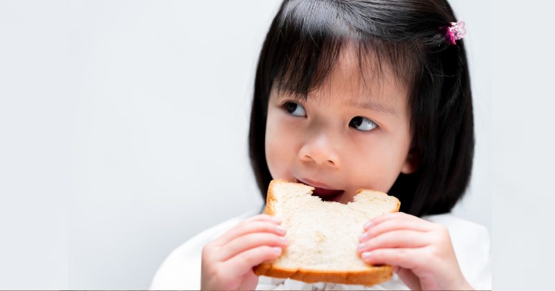 Menina comendo pão