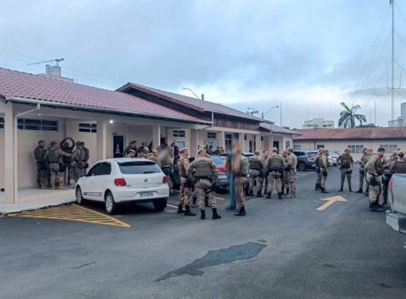 Policiais militares em frente à delegacia após cumprimento de mandados em operação 