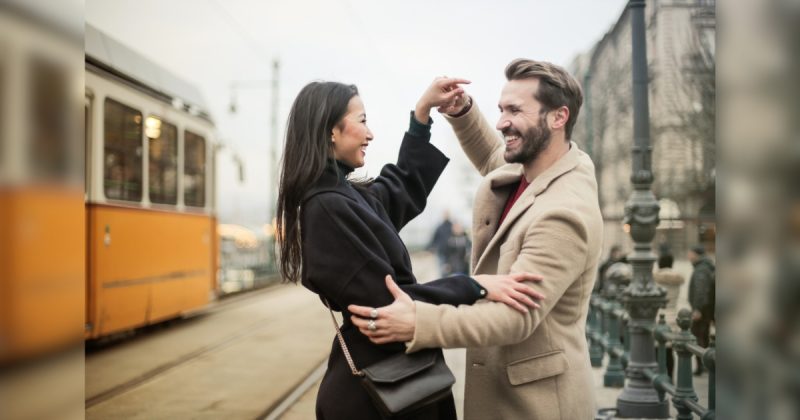 Casal se abraçando em frente a trem