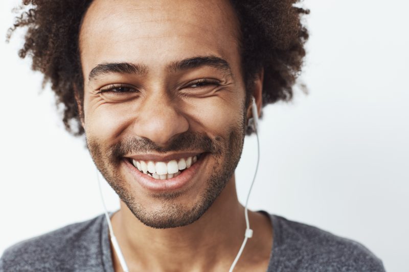 Homem sorrindo com fones de ouvido 