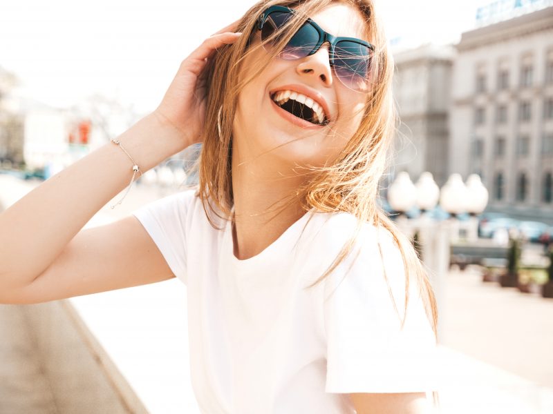 Mulher sorrindo com óculos de Sol