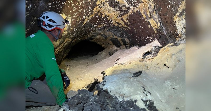 Cientista olhando para parede em caverna