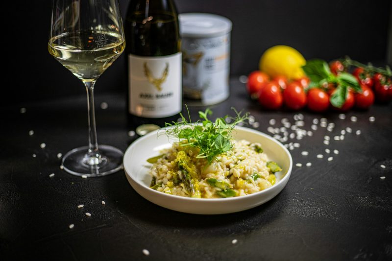 prato de risoto com vinho ao fundo 