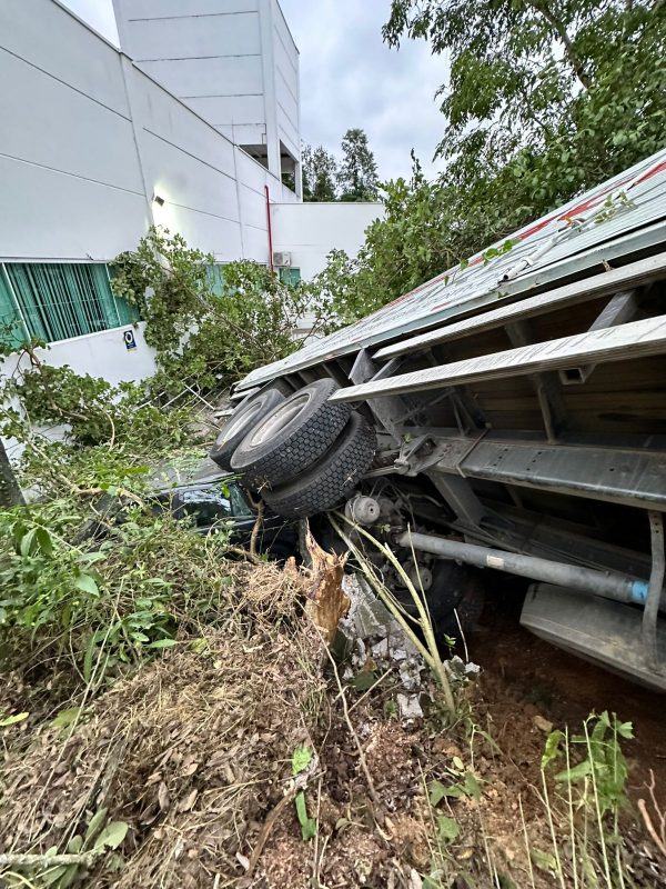 Foto do caminhão caído sobre carro em Blumenau