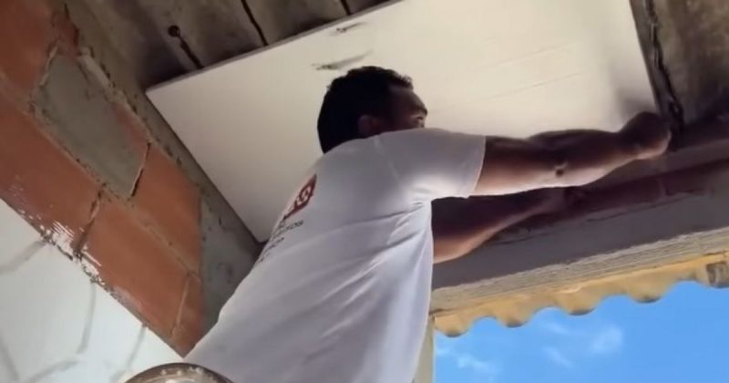 Pedreiro aplicando placas de isopor no telhado para acabar com calor